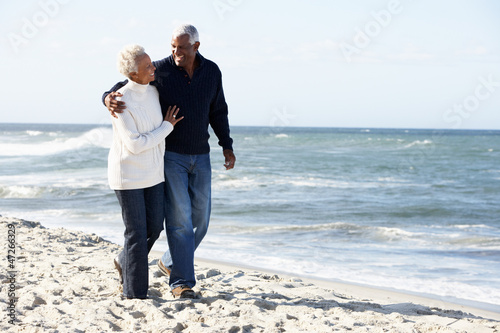 Photo: Senior Couple Walking Along Beach Together Senior Couple Walking Along Beach Together