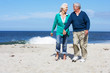 Senior Couple Walking Along Beach Together