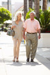 Senior Couple Walking Along Street Together