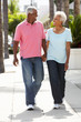 Senior Couple Walking Along Street Together