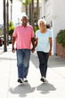Senior Couple Walking Along Street Together