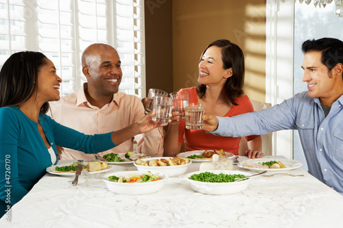 Photo: Group Of Friends Enjoying Meal At Home Group Of Friends Enjoying Meal At Home
