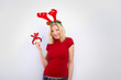 beautiful blonde woman with reindeer antlers is smiling