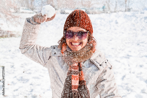 Photo: Happy young woman playing snowball fight Happy young woman playing snowball fight