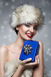 christmas picture of beautiful woman holding a blue present