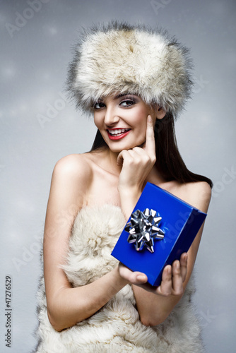 Photo: christmas picture of beautiful woman holding a blue present christmas picture of beautiful woman holding a blue present