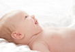 Cute adorable baby girl lying down and smiling isolated on white