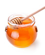 Glass jar of honey with wooden drizzler isolated on white