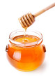 Glass jar of honey with wooden drizzler isolated on white