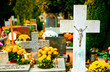 Cross with crucified Jesus Christ and flowers at cemetery Cross with crucified Jesus Christ and flowers at cemetery