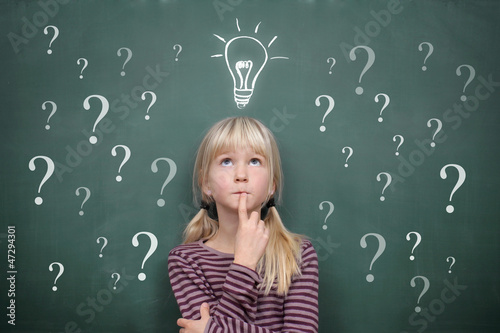 Photo: Schoolgirl at the Blackboard with Question Marks and Idea Schoolgirl at the Blackboard with Question Marks and Idea