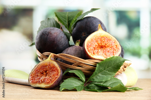 Photo: Ripe sweet figs with leaves in basket, Ripe sweet figs with leaves in basket,