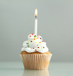 tasty birthday cupcake with candle, on grey background