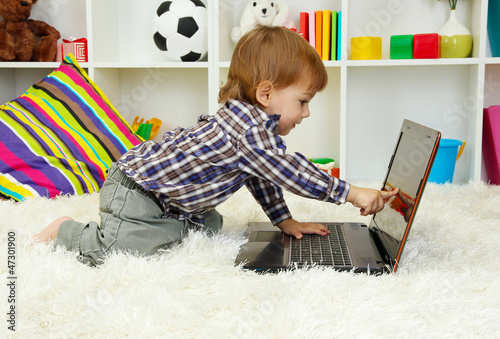 Photo: cute little boy and notebook in room cute little boy and notebook in room