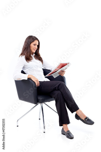 Photo: Casual 20s women reading newspaper, focused Casual 20s women reading newspaper, focused