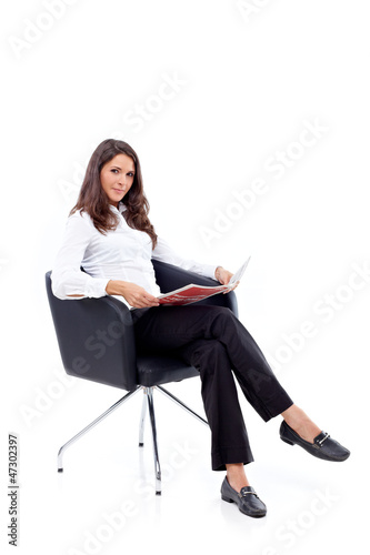 Photo: Casual 20s women sitting with newspaper, looking to camera Casual 20s women sitting with newspaper, looking to camera