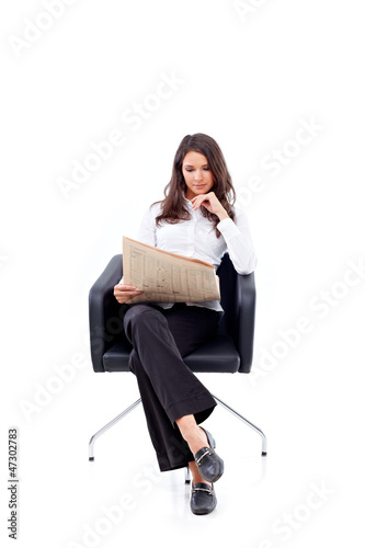 Photo: Casual 20s woman reading stock rates in newspaper 2 Casual 20s woman reading stock rates in newspaper 2