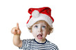 Kind mit Weihnachtsmütze zeigt hoch