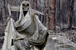 statue représentant la mort devant une forêt incendiée