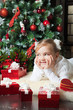 Happy girl with giftslying near christmas tree