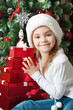 Smiling little girl in Santa hat with gifts
