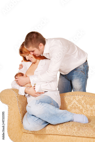 Photo: Happy young family sitting on the sofa Happy young family sitting on the sofa