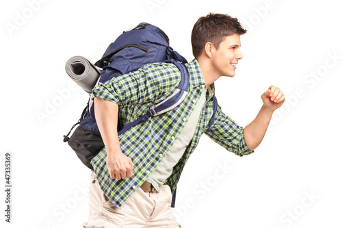 Photo: A young hiker with backpack running A young hiker with backpack running