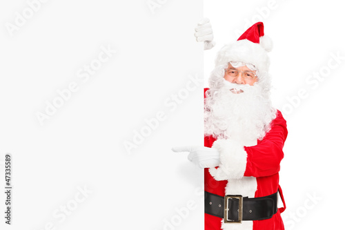 Photo: Santa claus posing next to a blank billboard and pointing Santa claus posing next to a blank billboard and pointing
