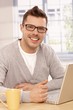 Foto: Handsome guy using laptop smiling Handsome guy using laptop smiling