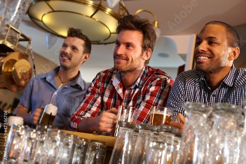 Photo: Friends having a drink at bar counter Friends having a drink at bar counter
