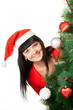 Photo: Woman in red cap looking out of Christmas tree Woman in red cap looking out of Christmas tree