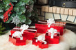 Red gift boxes near christmas tree and fireplace