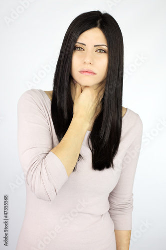 Photo: Serious beautiful woman sick with throat problem sore Serious beautiful woman sick with throat problem sore