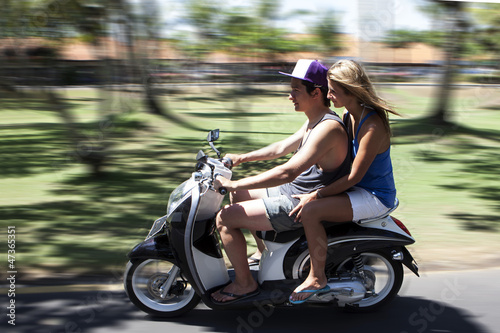 Photo: Happy couple traveling on moped Happy couple traveling on moped