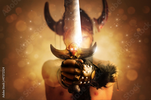 Photo: Fantastical portrait of a warrior with focus on powerful sword Fantastical portrait of a warrior with focus on powerful sword
