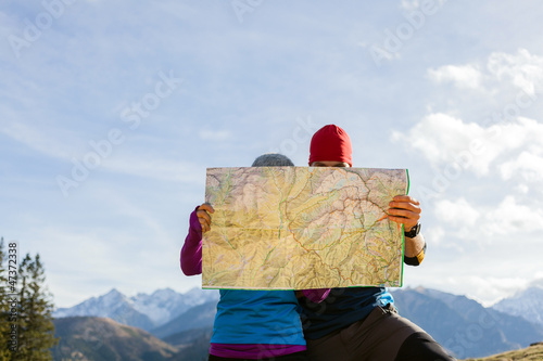 Photo: Couple hiking with map in mountains Couple hiking with map in mountains