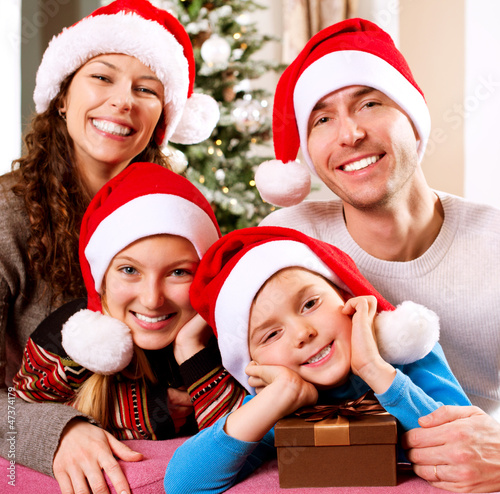 Photo: Christmas Family with Kids. Happy Smiling Parents and Children Christmas Family with Kids. Happy Smiling Parents and Children