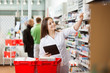 Photo: Smiling Woman Using Digital Tablet For Shopping At Supermarket Smiling Woman Using Digital Tablet For Shopping At Supermarket