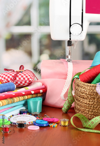 Photo: sewing machine and fabric on bright background sewing machine and fabric on bright background