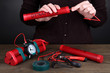Human makes timebomb on wooden table on black background