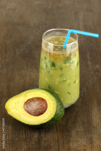 Photo: Useful fresh avocado and half avocado on wooden table close-up Useful fresh avocado and half avocado on wooden table close-up