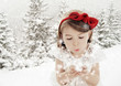 Foto: Three years old girl blowing smowflakes in winter landscape Three years old girl blowing smowflakes in winter landscape