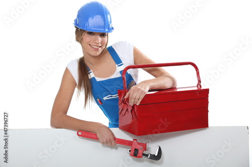 Photo: An attractive tradeswoman holding a pipe wrench and toolbox An attractive tradeswoman holding a pipe wrench and toolbox