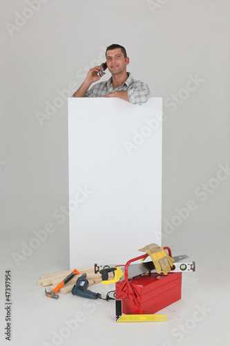 Photo: Carpenter stood by advertising whilst making a call Carpenter stood by advertising whilst making a call