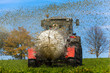 Traktor düngt mit Gülle ein Feld