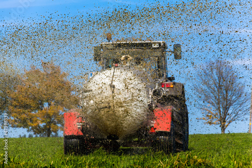 Photo: Traktor düngt mit Gülle ein Feld Traktor düngt mit Gülle ein Feld
