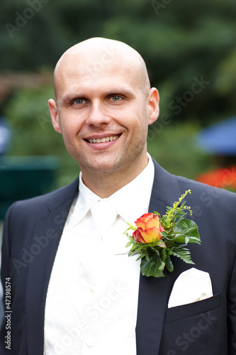 Photo: lächelnder Bräutigam mit Blumenanstecker lächelnder Bräutigam mit Blumenanstecker