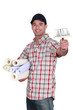 Man holding rolls of wallpaper