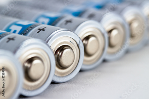 Photo: Several AA batteries in perspective closeup view on white Several AA batteries in perspective closeup view on white