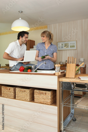 Photo: Young man and young woman smiling in kitchen Young man and young woman smiling in kitchen